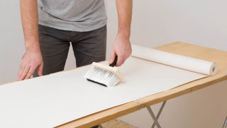 壁紙を刷毛で貼り付ける