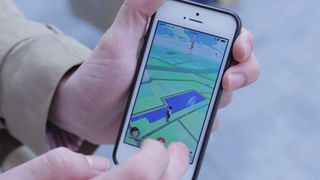 ポケモン Go を表示している携帯電話を持っている人