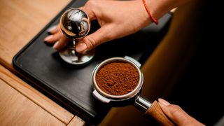 エスプレッソの作り方を説明するコーヒー粉が入ったポルタフィルター