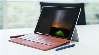 机の上に座って夜空とテントの画像を画面に表示するタブレット