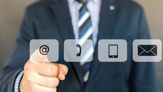スーツを着た男性が 4 つの通信アイコンから 1 つを選択している画像。