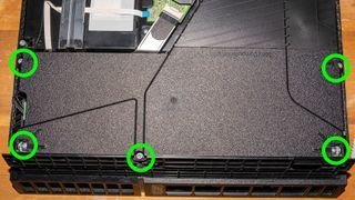 取り外す必要があるネジが緑色の円で強調表示されている PS4 電源の写真
