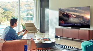 広い部屋でサムスンのテレビでビデオゲームをしている男性