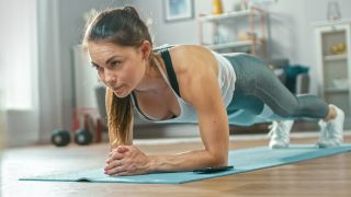 マットの上で板運動をする女性