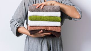 タオルの山を抱える女性たち
