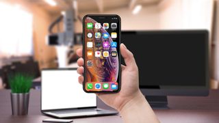 iPhone でページ全体をスクリーンショットする方法に関する記事を表す iPhone がかざされています。