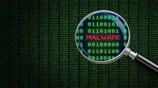 コンピューターのマシンコード内の「マルウェア」という単語を拡大する虫眼鏡