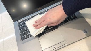 湿ったタオルで掃除するノートパソコンのキーボード