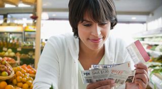 食料品店でクーポンを使って買い物をする女性