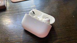 AirPods Pro ケースを開いて、AirPods Pro を中に入れ、緑色のライトを点灯させた状態