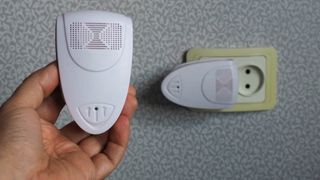 2 つの超音波害虫忌避装置 (1 つは壁に差し込み、もう 1 つは手に持つ)