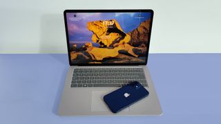 キーボードの上に電話機を置いた MacBook