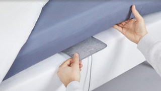 Withings Sleep Analyzer をマットレスの下に置く男性
